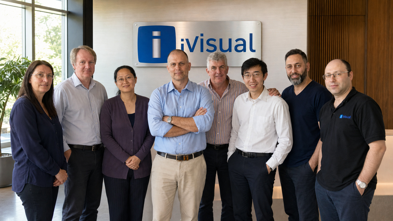 Sam Bonkowski with the early iVisual team beneath the iVisual company sign.